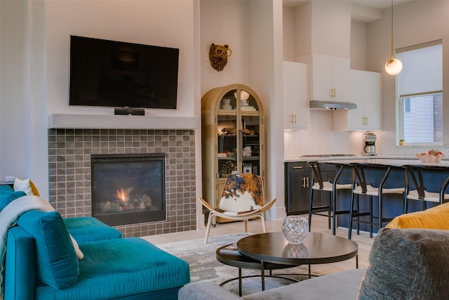 living room featuring a towering ceiling and a tile fireplace