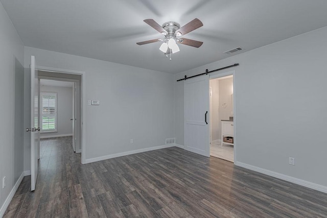 3336 Whitehall Dr, Dallas, TX 75229 - empty room with dark wood-style flooring, ceiling fan, a barn door, and baseboards