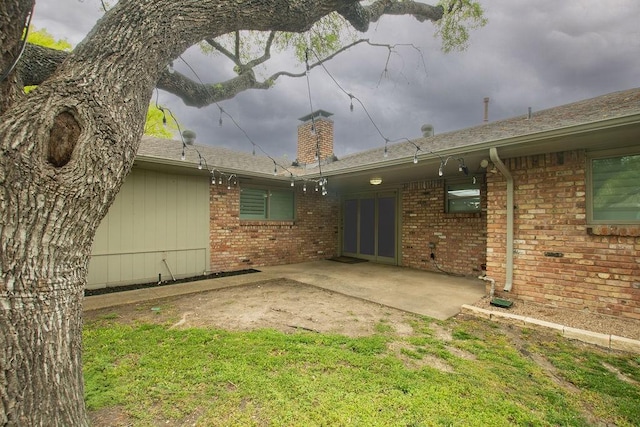 3336 Whitehall Dr, Dallas, TX 75229 - back of house with brick siding, a patio, a chimney, and a shingled roof