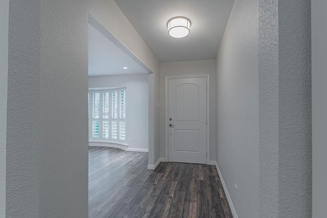 3336 Whitehall Dr, Dallas, TX 75229 - hallway featuring a textured wall, dark wood-style floors, and baseboards
