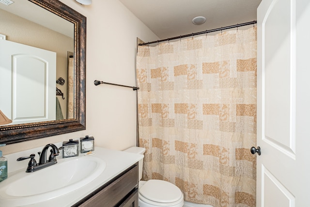 bathroom featuring a shower with shower curtain, toilet, and vanity
