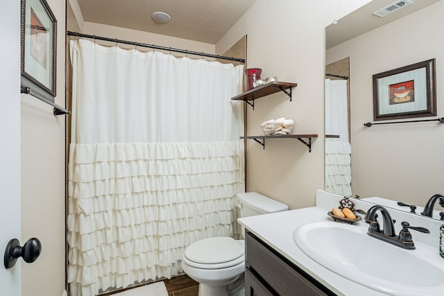 bathroom featuring visible vents, toilet, wood finished floors, curtained shower, and vanity