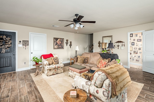 living area with a ceiling fan, baseboards, wood tiled floor, and visible vents