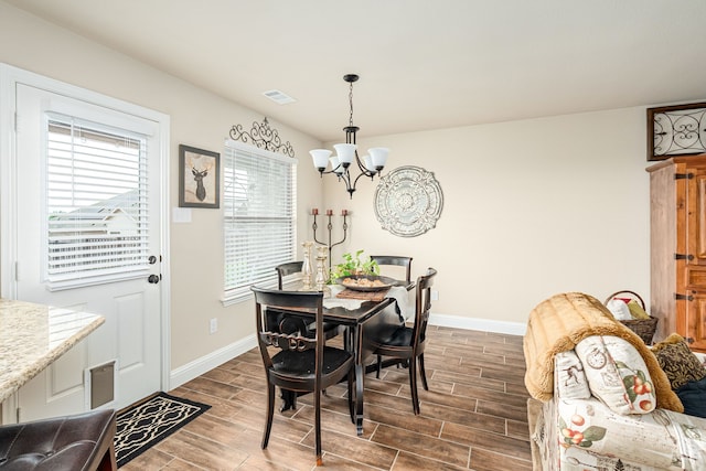 dining room featuring baseboards, an inviting chandelier, and wood finish floors