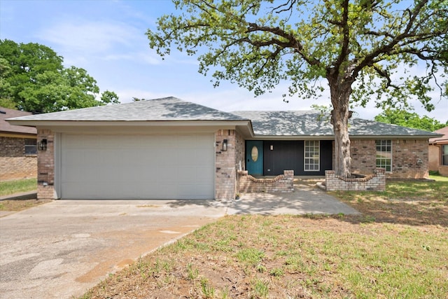 single story home with brick siding, an attached garage, and driveway