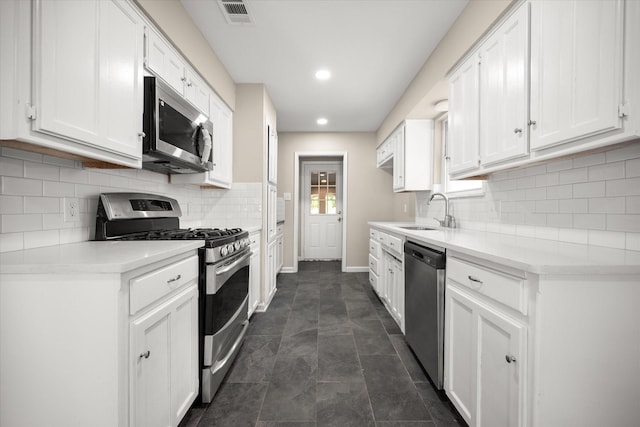 kitchen featuring white cabinets, stainless steel appliances, visible vents, and a sink
