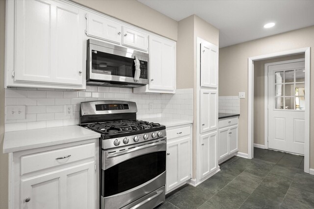 kitchen featuring white cabinets, light countertops, appliances with stainless steel finishes, and tasteful backsplash