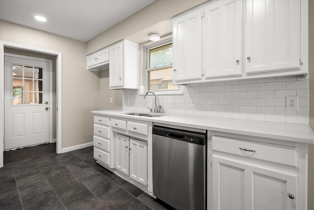 kitchen featuring white cabinets, stainless steel dishwasher, a sink, and baseboards