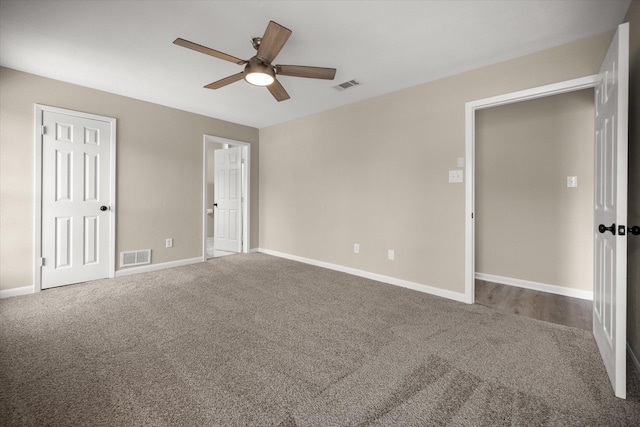 unfurnished bedroom with baseboards, visible vents, carpet floors, and ceiling fan