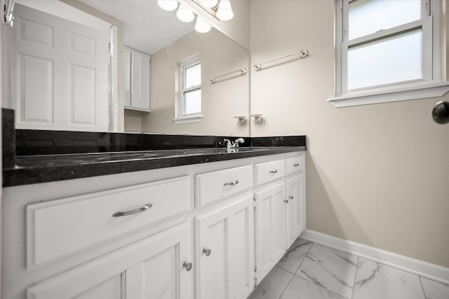 bathroom featuring marble finish floor, baseboards, and vanity
