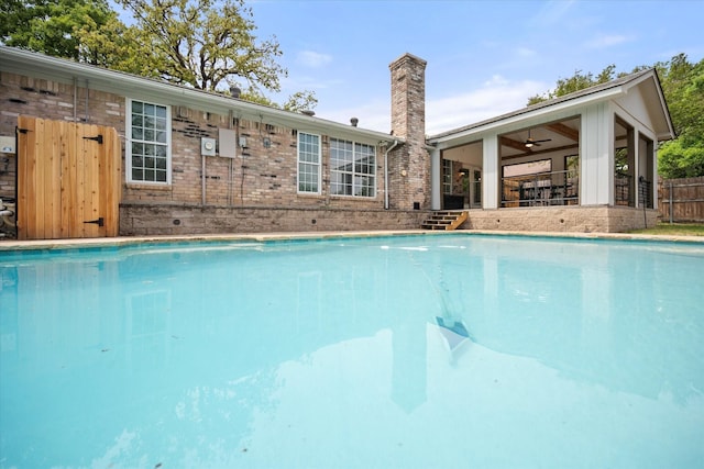 outdoor pool with fence and a ceiling fan