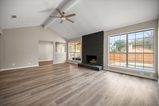 unfurnished living room featuring baseboards, a ceiling fan, wood finished floors, and beamed ceiling