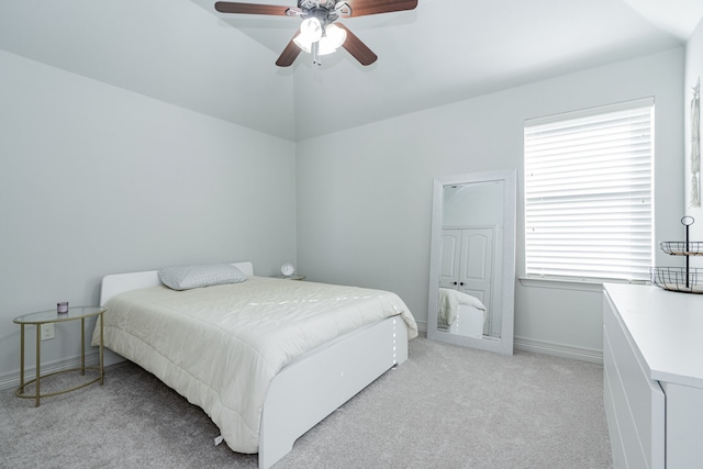 bedroom featuring baseboards, lofted ceiling, a ceiling fan, and light colored carpet