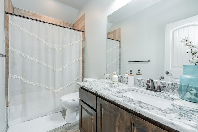 bathroom with toilet, vanity, and curtained shower