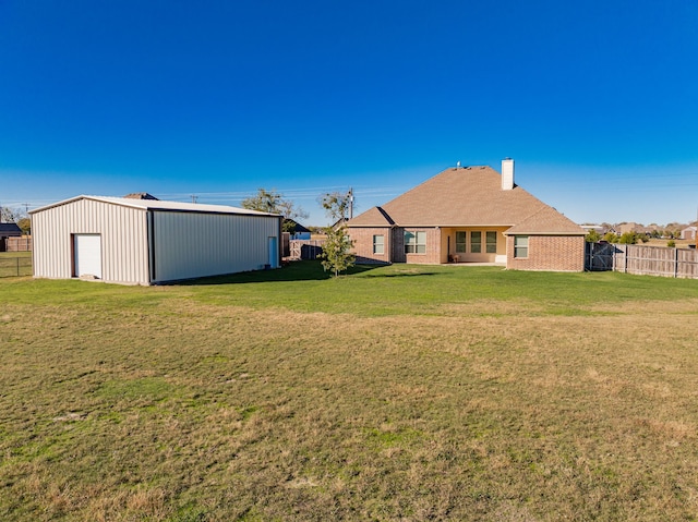 exterior space featuring a chimney, an outdoor structure, fence, a lawn, and a pole building