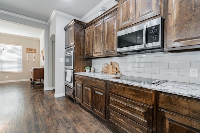 kitchen with decorative backsplash, crown molding, dark wood finished floors, dark brown cabinetry, and appliances with stainless steel finishes
