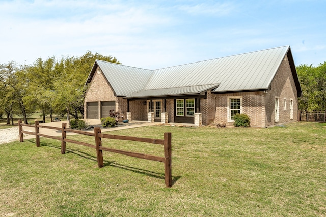 view of front of house with an attached garage, brick siding, a front lawn, and metal roof
