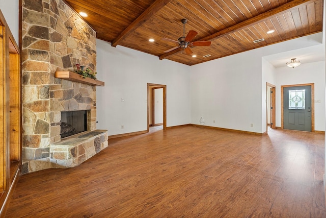 unfurnished living room with wood ceiling, a ceiling fan, a fireplace, wood finished floors, and beamed ceiling