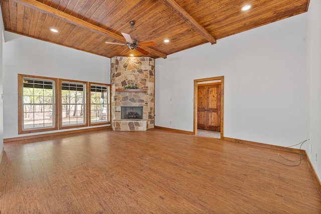 unfurnished living room with wooden ceiling, a ceiling fan, wood finished floors, and beamed ceiling