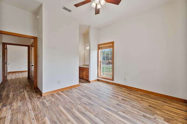 unfurnished room featuring baseboards, visible vents, light wood-style flooring, and ceiling fan
