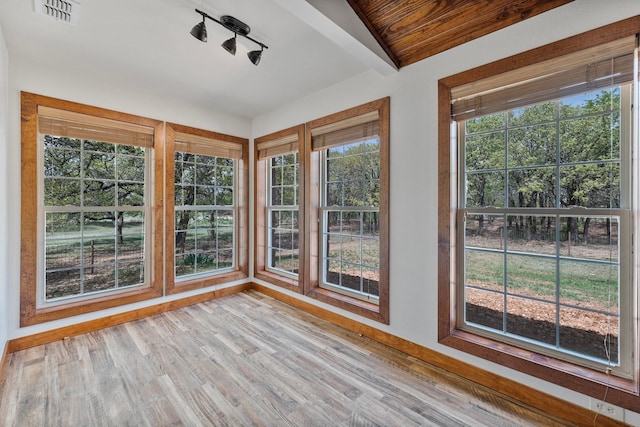 unfurnished sunroom with baseboards, visible vents, and wood finished floors