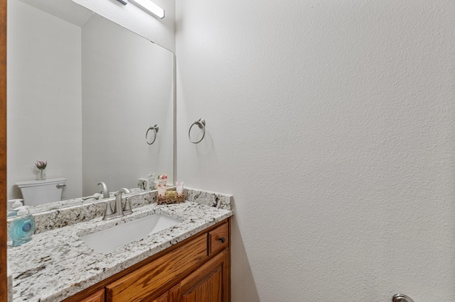 half bathroom with toilet and vanity