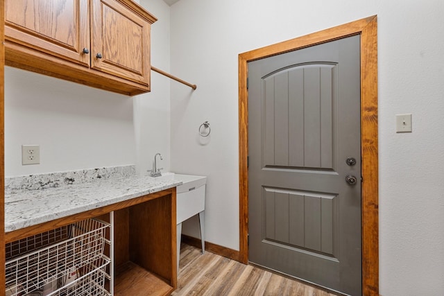 laundry room with baseboards and light wood-style floors
