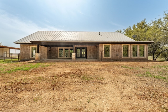back of property with brick siding and metal roof