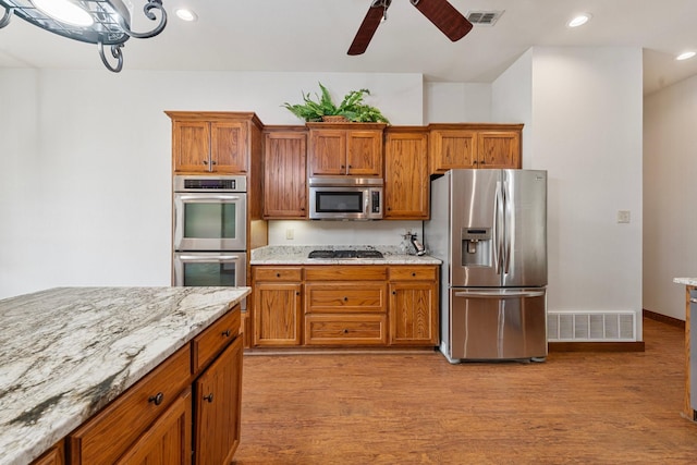 kitchen featuring visible vents, light wood-style floors, ceiling fan, and stainless steel appliances