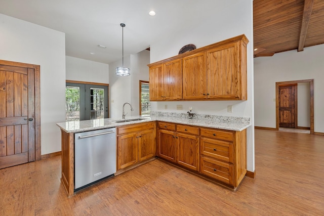 kitchen with stainless steel dishwasher, light wood-type flooring, brown cabinetry, and a sink