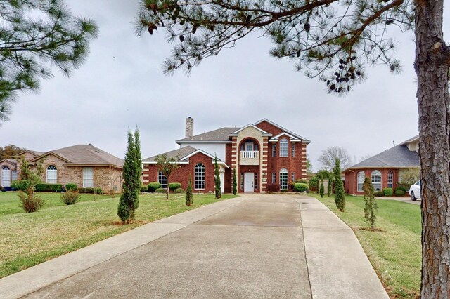 3120 Cantura Dr, Mesquite, TX 75181 - colonial home featuring a chimney, brick siding, a front yard, and driveway