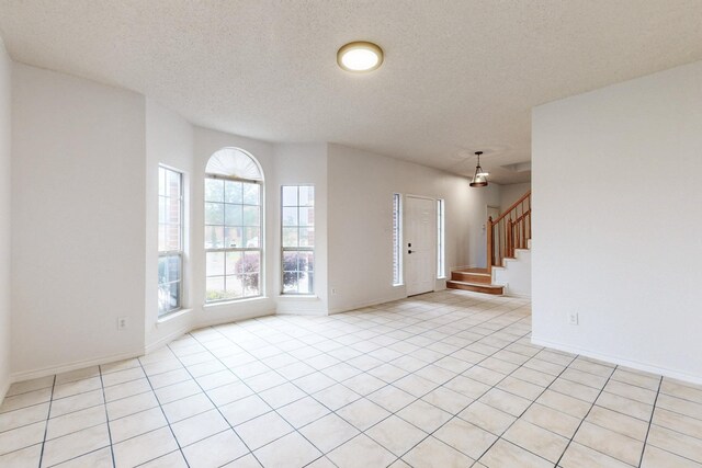 3120 Cantura Dr, Mesquite, TX 75181 - entryway featuring stairs, baseboards, light tile patterned floors, and a textured ceiling