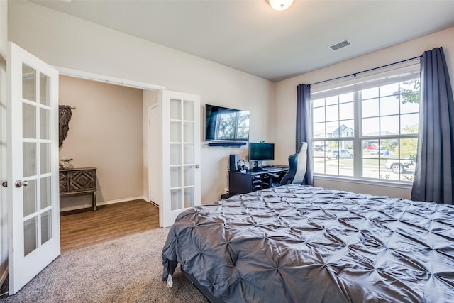 carpeted bedroom with french doors, baseboards, and visible vents