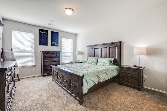 bedroom with light colored carpet, visible vents, and baseboards
