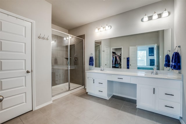 bathroom featuring double vanity, a sink, a walk in closet, and a shower stall
