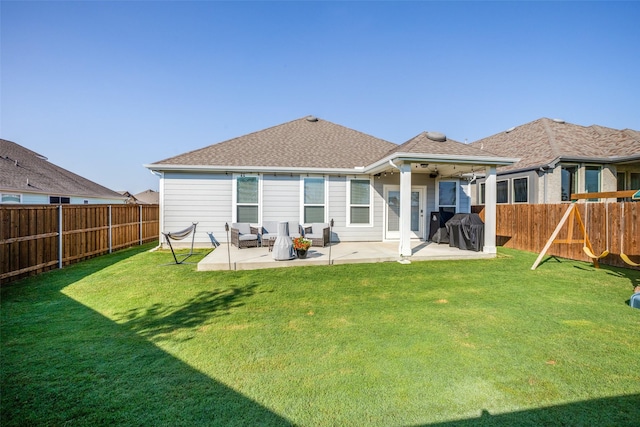 rear view of house featuring roof with shingles, a fenced backyard, a patio, a lawn, and a playground