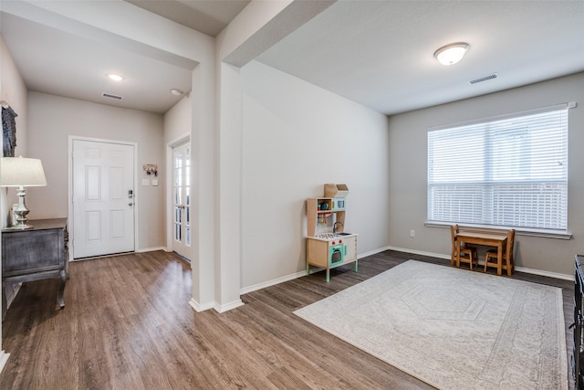 foyer entrance with a wealth of natural light, visible vents, and wood finished floors