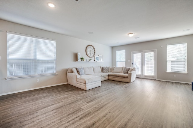 unfurnished living room with baseboards and wood finished floors