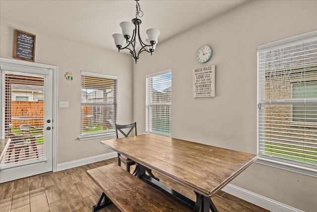 dining room featuring baseboards, a chandelier, and wood finished floors
