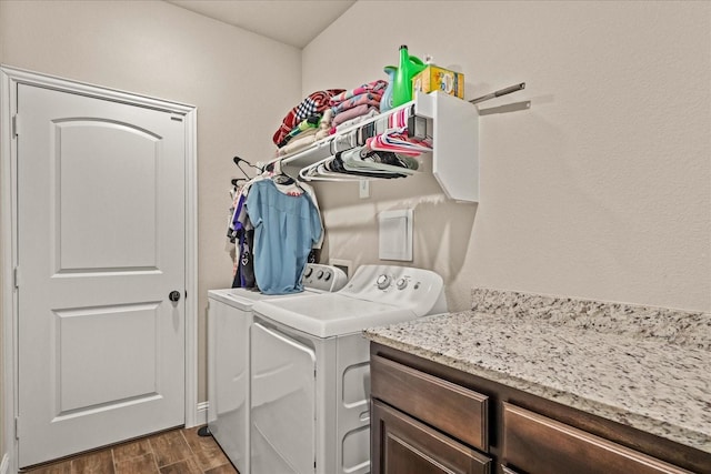 clothes washing area with washing machine and clothes dryer and dark wood finished floors