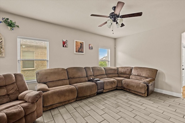 living room featuring baseboards and a ceiling fan