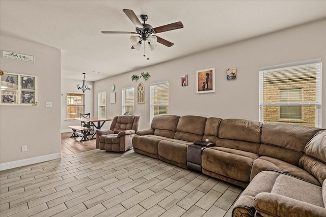 living area featuring light wood finished floors, ceiling fan with notable chandelier, and baseboards