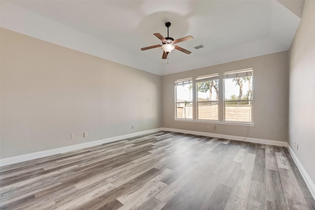 spare room featuring visible vents, baseboards, a ceiling fan, and wood finished floors