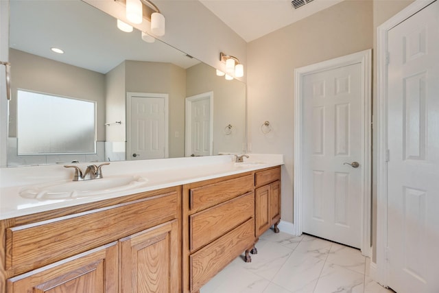 bathroom featuring marble finish floor, double vanity, a sink, and visible vents