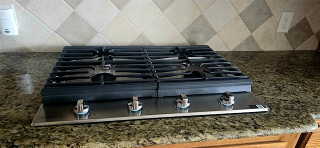 details with stainless steel gas stovetop and backsplash