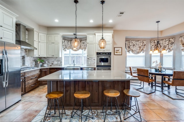 1179 Marquette Dr, Frisco, TX 75033 - kitchen with wall chimney range hood, appliances with stainless steel finishes, plenty of natural light, a sink, and recessed lighting