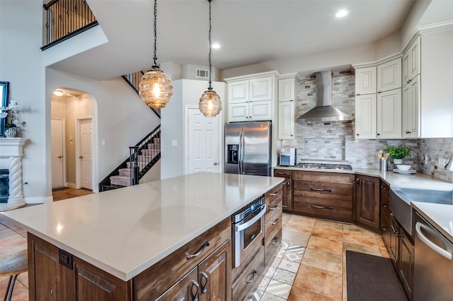 1179 Marquette Dr, Frisco, TX 75033 - kitchen with appliances with stainless steel finishes, wall chimney range hood, decorative backsplash, white cabinetry, and recessed lighting