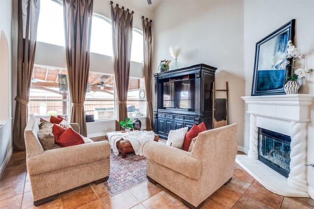1179 Marquette Dr, Frisco, TX 75033 - living area with a high ceiling, a glass covered fireplace, healthy amount of natural light, ceiling fan, and tile patterned floors