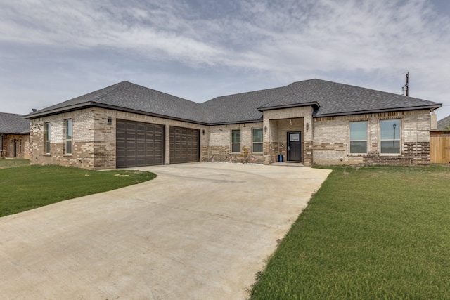 prairie-style house featuring brick siding, an attached garage, and roof with shingles
