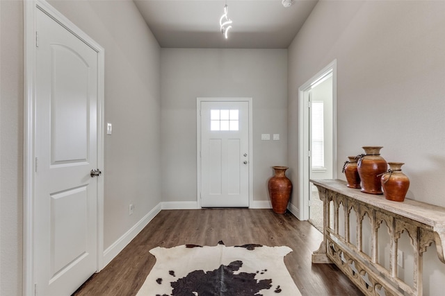 foyer entrance with wood finished floors and baseboards